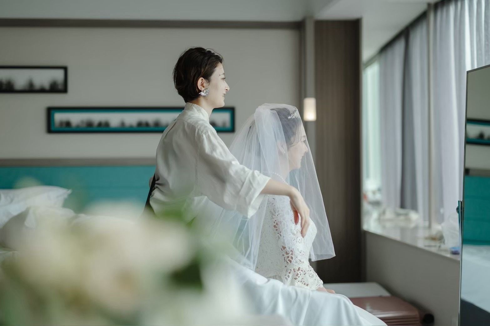 花嫁のドレス姿を整えるヘアメイクアーティスト
