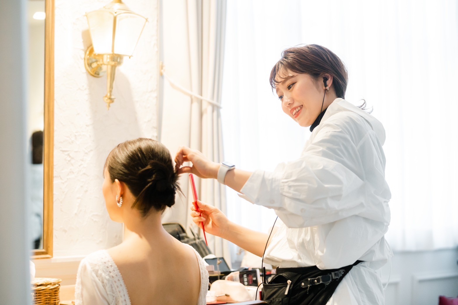 花嫁のヘアを整えるヘアメイクスタッフ