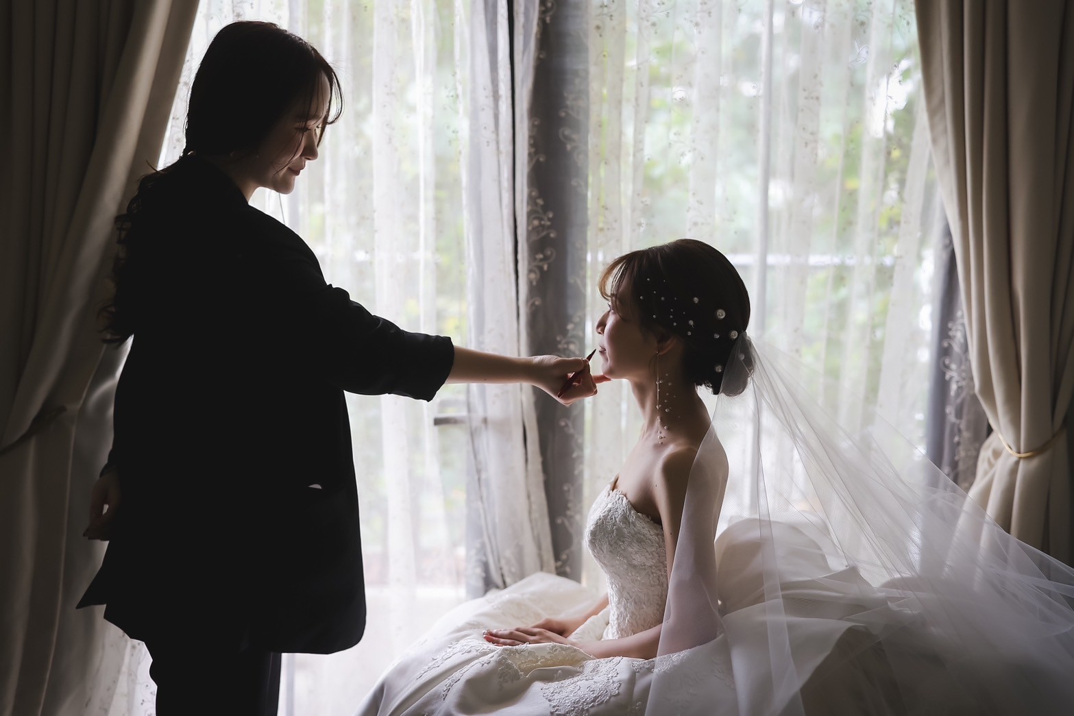 花嫁のメイクを整えるヘアメイクスタッフ